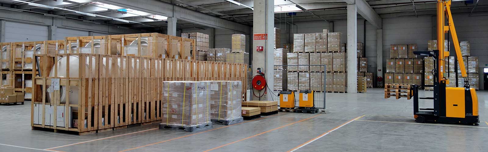 warehouse filled with new machinery components being moved