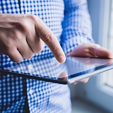 The man uses a tablet PC. Modern gadget in hand.