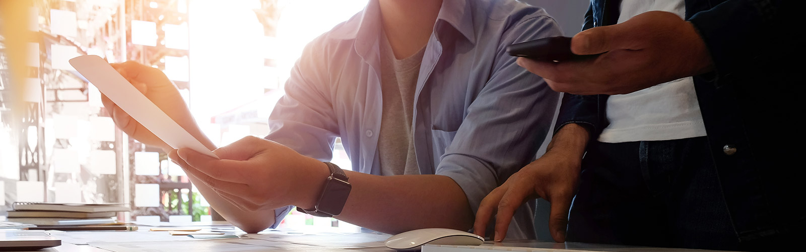 two men at desk looking at paperwork