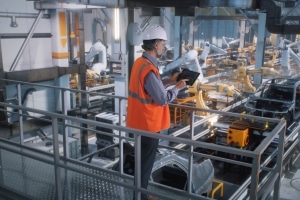 foreman walking through a production line using condition monitoring software to review the operation of their machinery