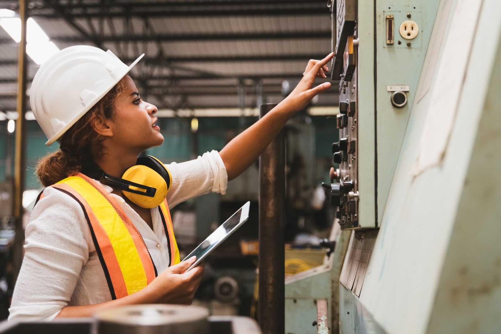 manufacturing plant worker using a tablet to access their equipment monitoring software