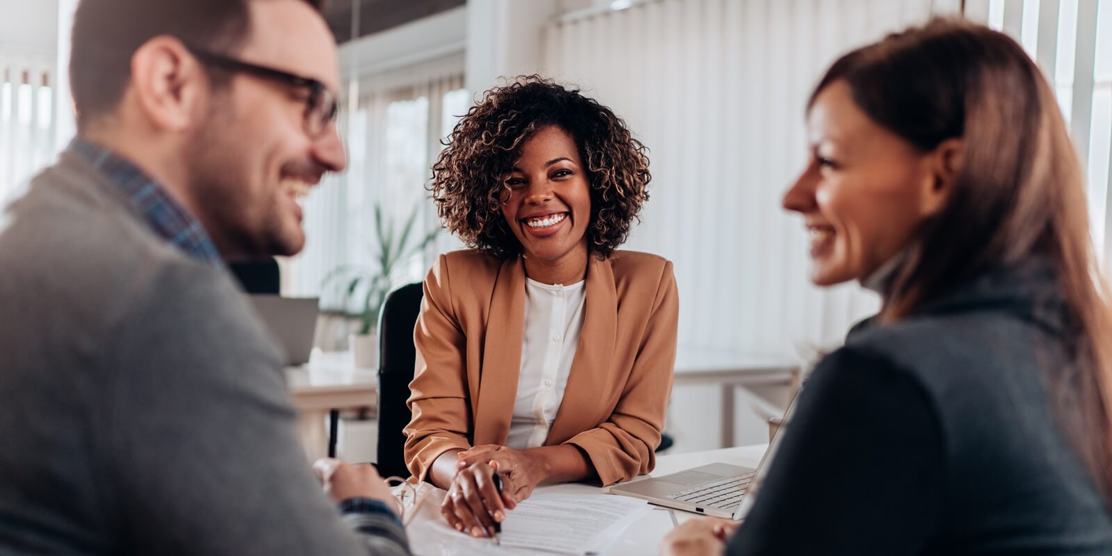 couple consulting with a female financial manager at the bank