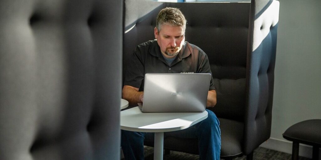 man working on a laptop while sitting on sofa