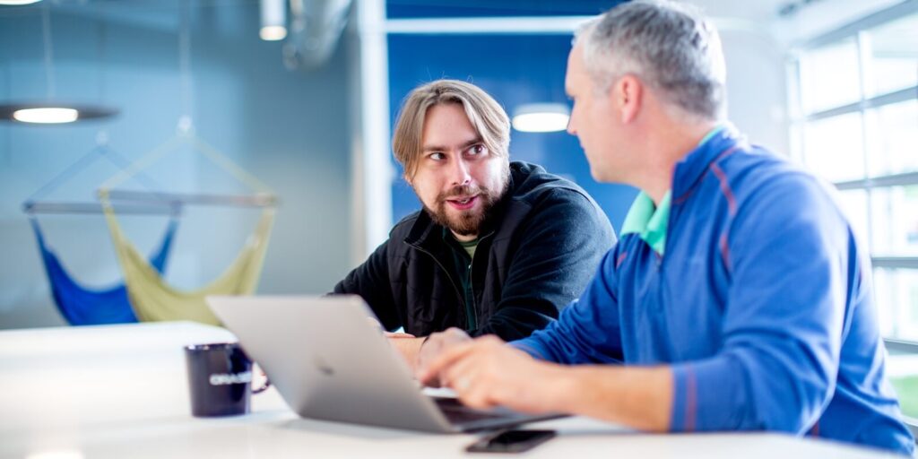 two employees sitting in an office and discussing some project details