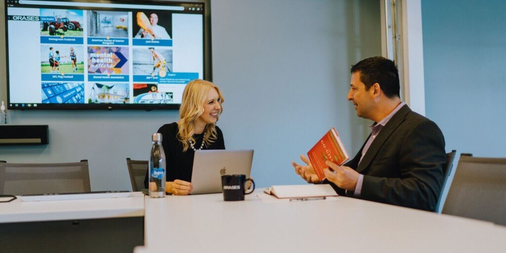 man and a woman are sitting at a conference table in a professional setting