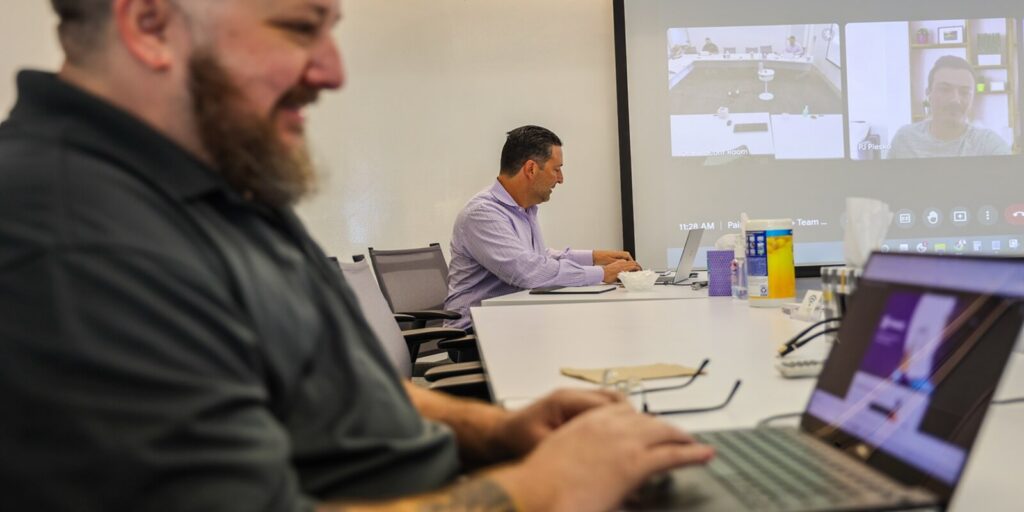 employees smiling and working on their laptops