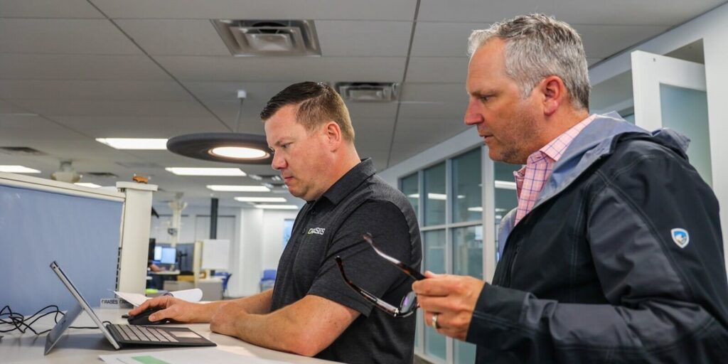 two male collegues looking at laptop