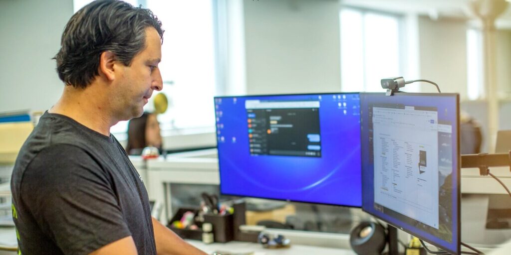 man working of a computer system with multi-screen